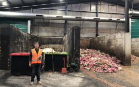Ecogas co-founder Andrew Fisher standing next to a pile of food waste at the company's Papakura plant