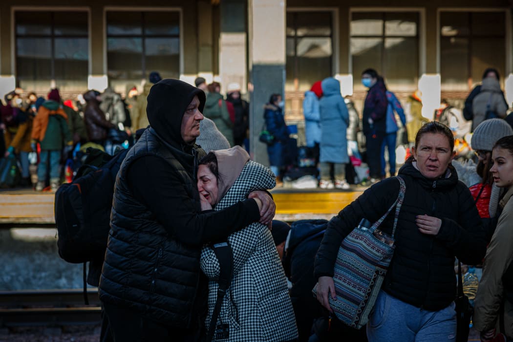 A man hugs his wife before she boards an evacuation train at Kyiv central train station on February 28, 2022.