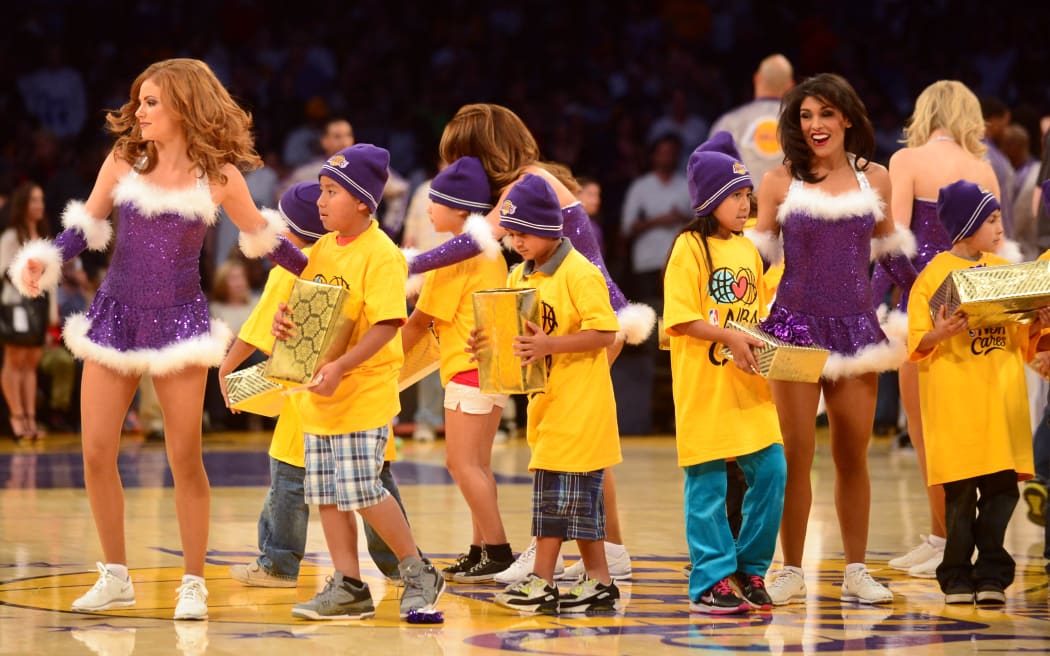 Children on the court receive Christmas gifts ahead of NBA action between the Los Angeles Lakers and the Miami Heat in their Christmas Day matchup at Staples Center in Los Angeles, California on December 25, 2013.