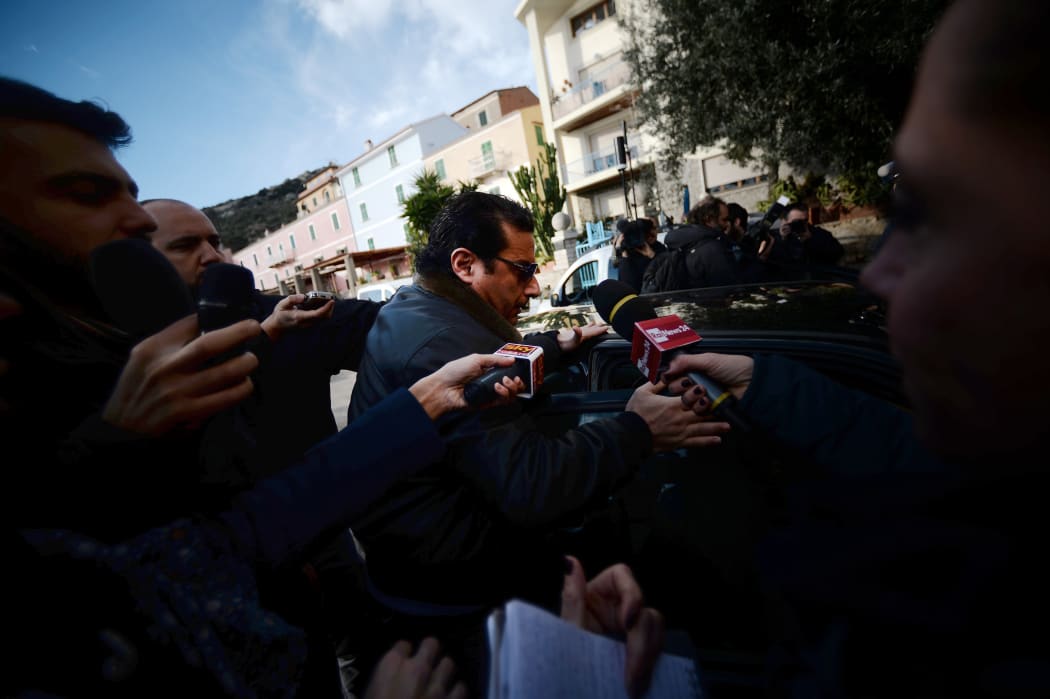 The Costa Concordia captain is surrounded by media as he arrives back at Giglio Island.