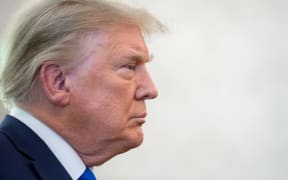In this file photo US President Donald Trump looks on during a ceremony presenting the Presidential Medal of Freedom to wrestler Dan Gable in the Oval Office of the White House in Washington, DC on 7 December 2020. -