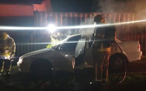 Firefighters extinguish a fire in a Whangārei woman's car, one of a spate of arson attacks in the suburb of Tikipunga.