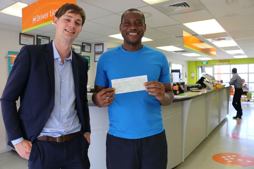 Success! Allen Muyengwa (right) holds his restricted driver licence with Mentor Ross Wood.