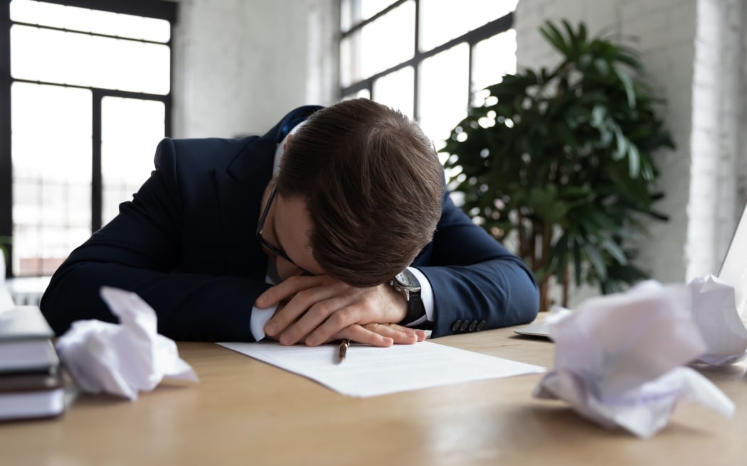 Tired male employee or worker feel fatigue exhaustion sleep or take nap at workplace, overwhelmed exhausted businessman fall asleep in office, preparing business report on deadline, overwork concept