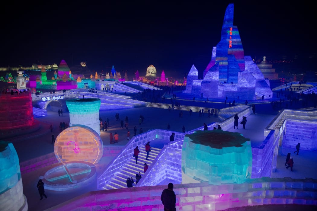 People visit ice sculptures illuminated by coloured lights marking the opening of the 2017 Harbin Ice and Snow Festival.