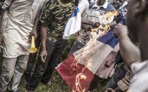 Protesters burn a French flag in Bamako during a demonstration against French influence in the country.
