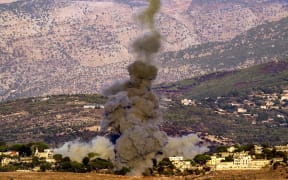 A smoke plume erupts after an Israeli airstrike targeted the outskirts of the village of Ibl al-Saqi in southern Lebanon on September 30, 2024. (Photo by Rabih DAHER / AFP)