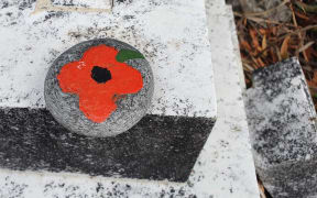 An ANZAC poppy stone made by the children from the Matakana school.