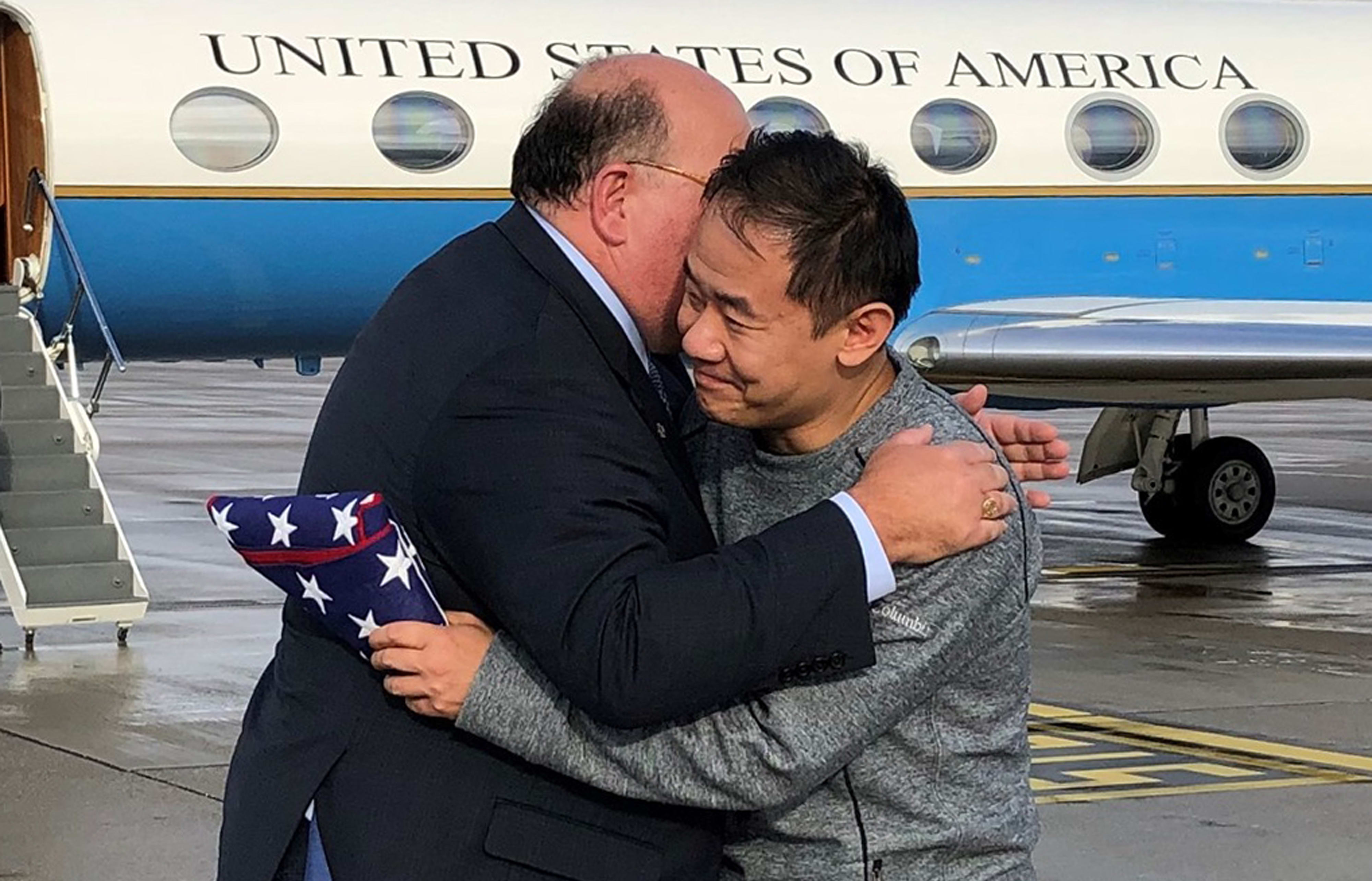 US Ambassador to Switzerland Edward T. McMullen, Jr. presents a US flag to and welcomes Xiyue Wang on arrival in Switzerland after his release from Iran on December 7, 2019.