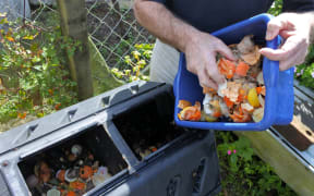 Man emptying a container full of domestic food waste, ready to be composted.