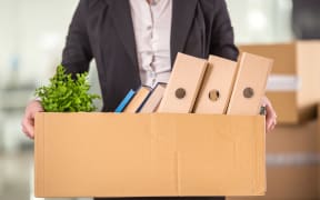 Close-up. Smiling young businesswoman holding cardboard box with her things.