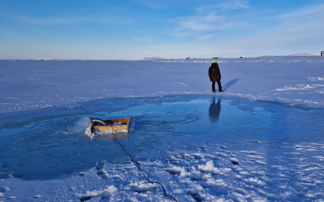 A member of the Real Ice team testing the submersible pump during field trials in Nome, Alaska, in February 2023.