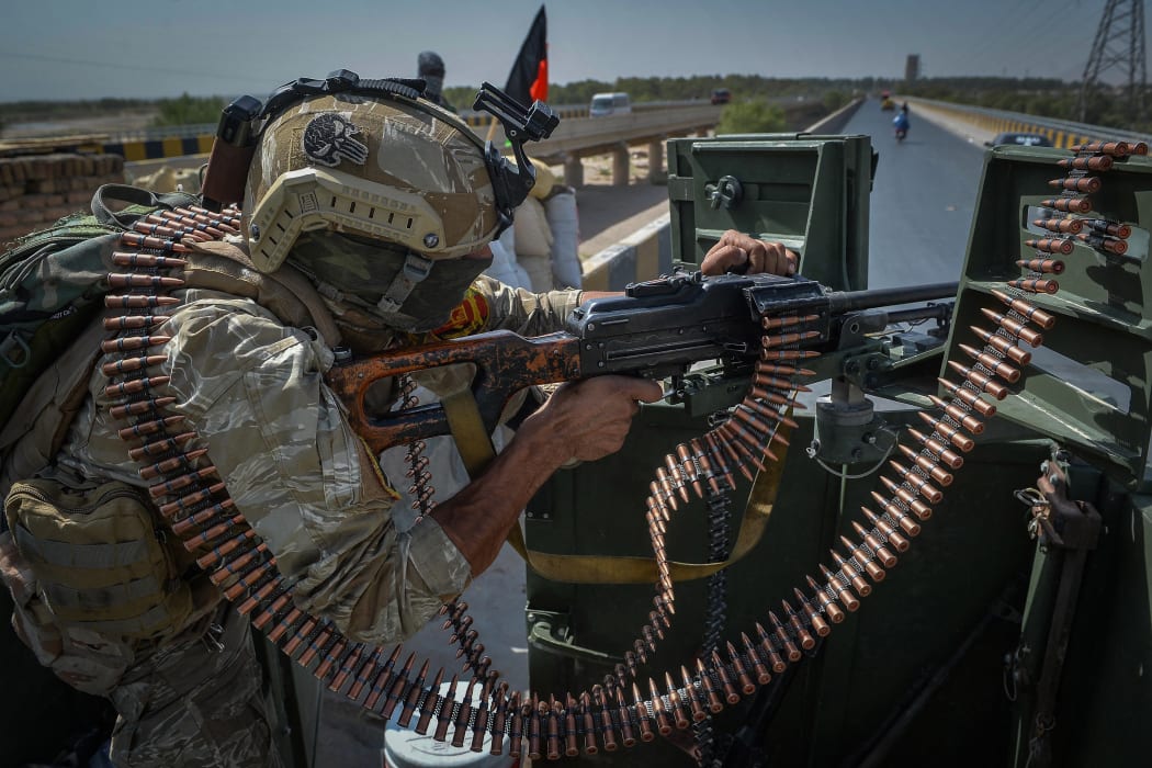 A security personnel stands guard on top of a vehicle outside United Nations Assistance Mission in Afghanistan (UNAMA) office compound in Guzara district of Herat province on 31 July, 2021.