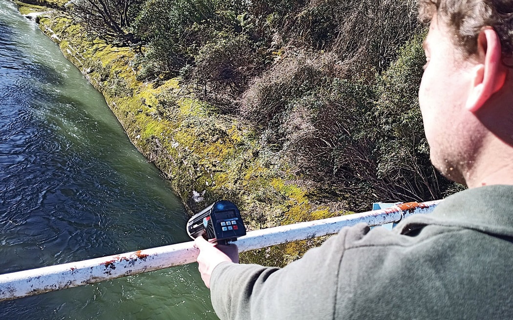 Regional council hydrology staff undertaking water monitoring with one of the new water radar guns.