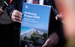 Finance minister Grant Robertson showing the cover of Budget 2023 the day before its reveal