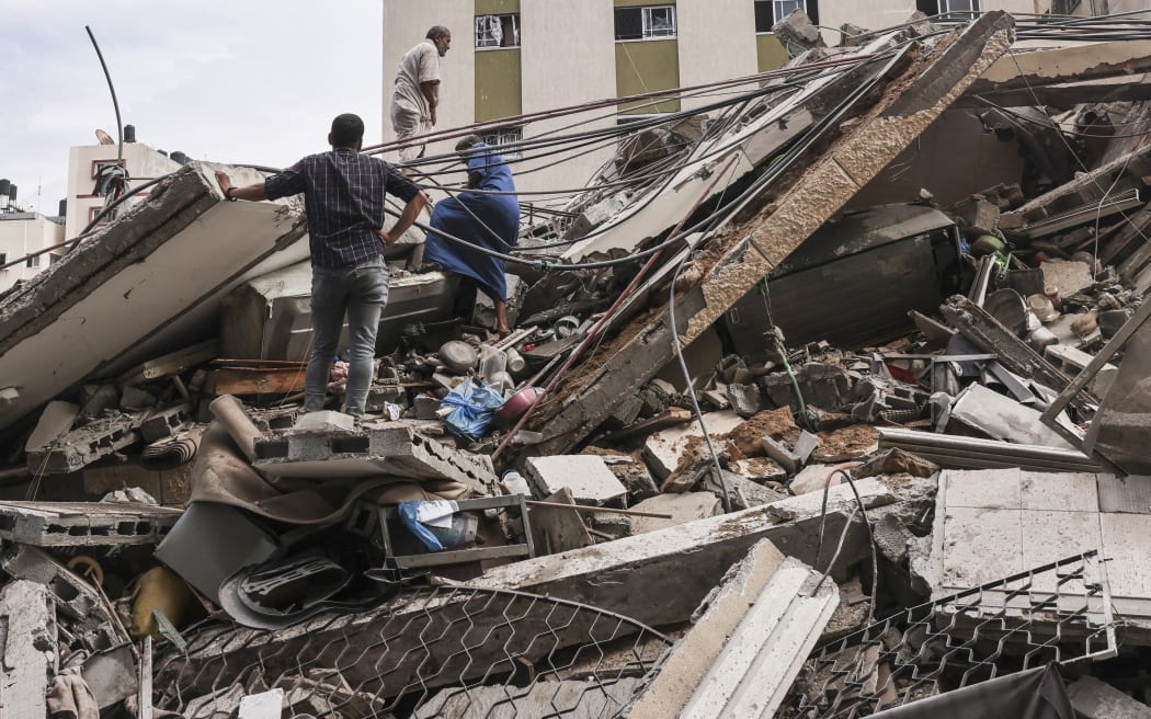 People assess the destruction cause by Israeli air strikes in Gaza City.