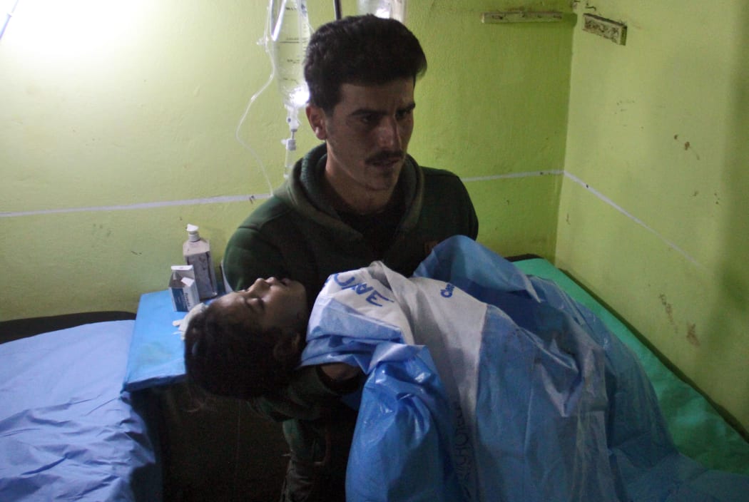 An unconscious Syrian child is carried at a hospital in Khan Sheikhun, a rebel-held town in the northwestern Syrian Idlib province, following a suspected toxic gas attack on April 4, 2017.