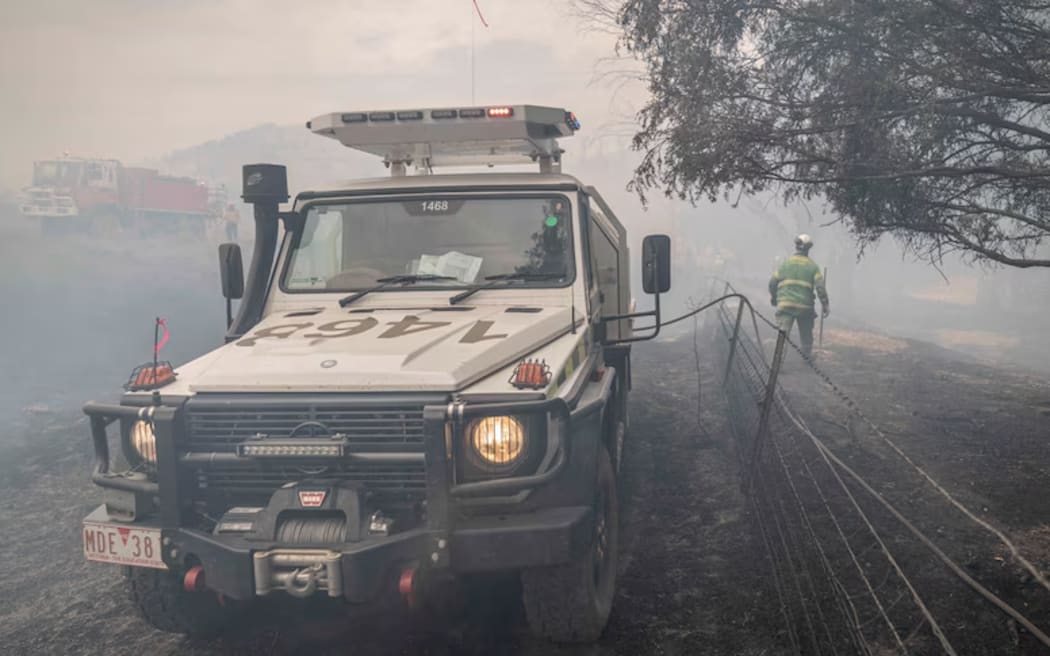 Forest Fire Management crews work to make the roads safe for residents returning to fire-impacted areas. ()