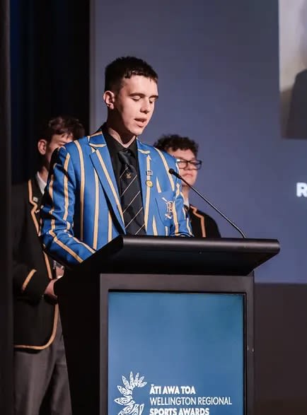 Toby Ireland speaking at a stage podium for the Wellington Regional Sports Awards.