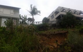 Michael Robertson's house (right) has been condemned until further notice because the soft ground underneath could mean his house goes down bank in another downpour.
