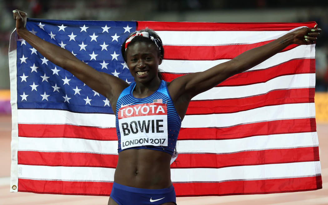 Tori Bowie of USA celebrates with a USA flag after finishing 1st in the Women's 100 metres final to be crowned World Champion, 2017.