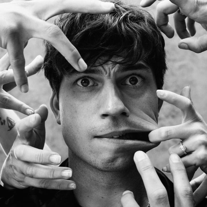 Choreographer Corey Baker with hands around his face mimicking 'Thing' from the TV show Wednesday.