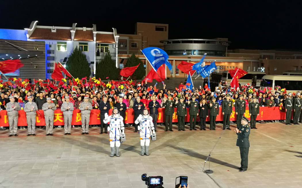 Taikonauts Jing Haipeng and Chen Dong wave during the launch ceremony of the Shenzhou-11 manned space mission at the Jiuquan Satellite Launch Center