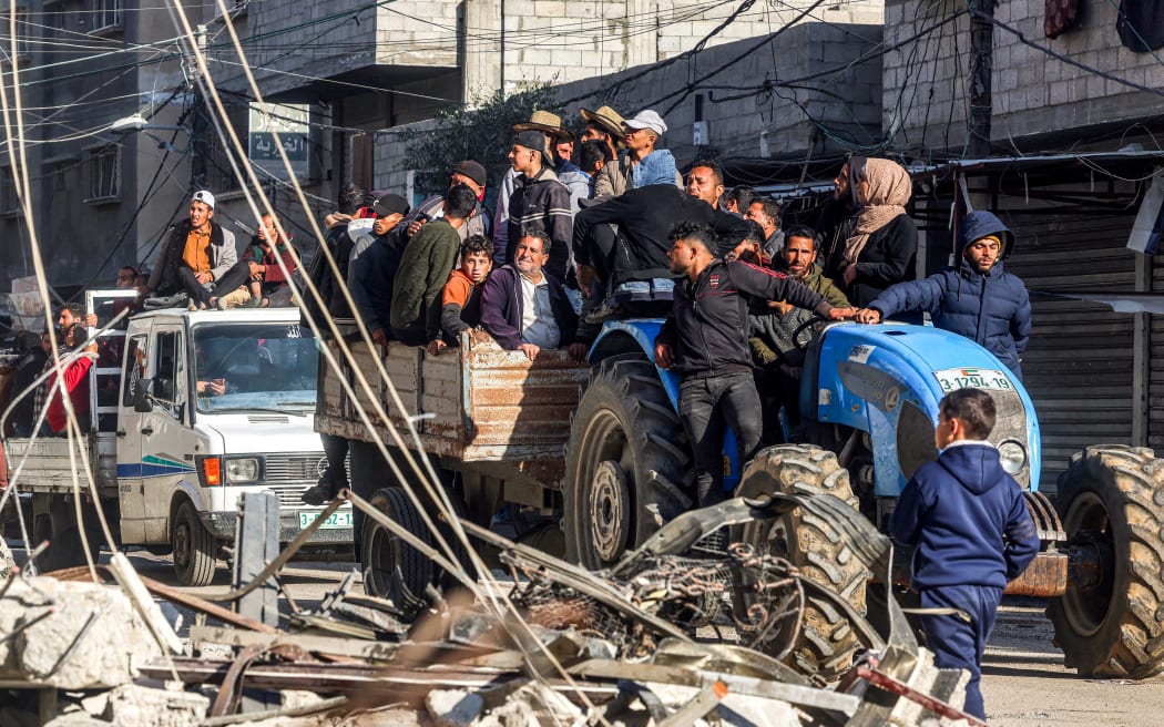 People ride in a cart pulled by a tractor past the rubble of a destroyed building and a mosque minaret in Rafah in the southern Gaza Strip on February 14, 2024 amid the ongoing conflict between Israel and the Palestinian militant group Hamas.