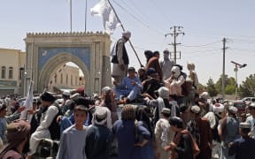 Taliban fighters stand on a vehicle along the roadside in Kandahar on Friday.