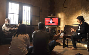 People attend a televised speech by the leader of the Hezbollah movement Hassan Nasrallah inside a house in the southern Lebanese village of Zawatar on September 19, 2024. Lebanon's powerful Hezbollah chief said on September 19 that Israel will not be able to return residents of the north displaced by 11 months of cross-border exchanges to their homes through military escalation. (Photo by Ammar Ammar / AFP)