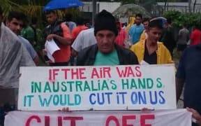 Refugees hold placards during the 91st day of protest inside the Manus Island detention centre, 30/10/17.
