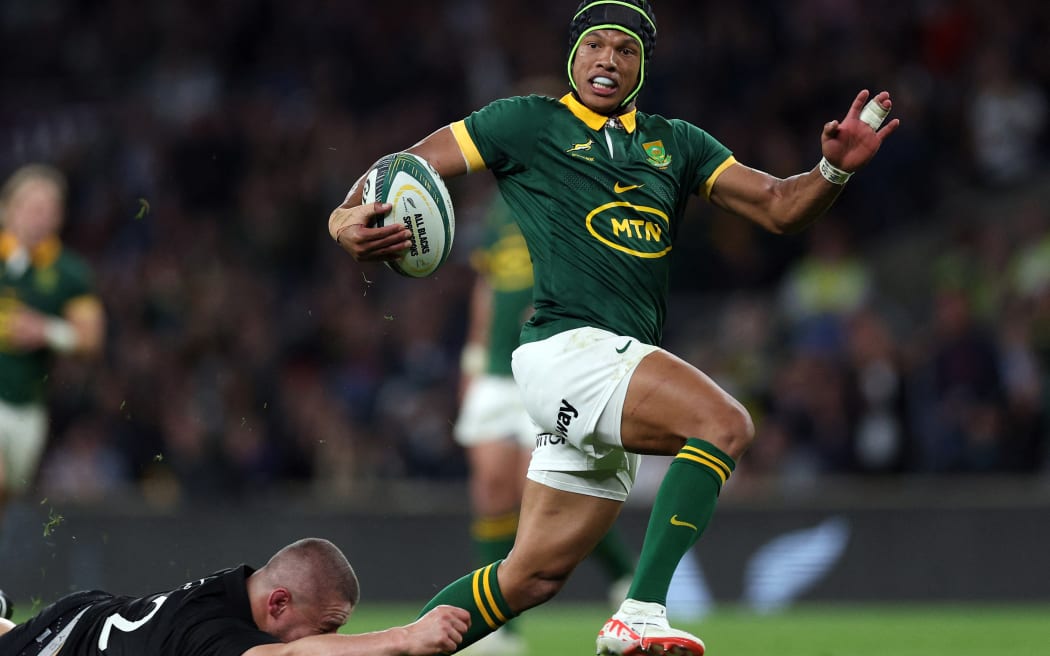 South Africa's wing Kurt-Lee Arendse breaks clear to score a try during the match between New Zealand and the Springboks at Twickenham Stadium.