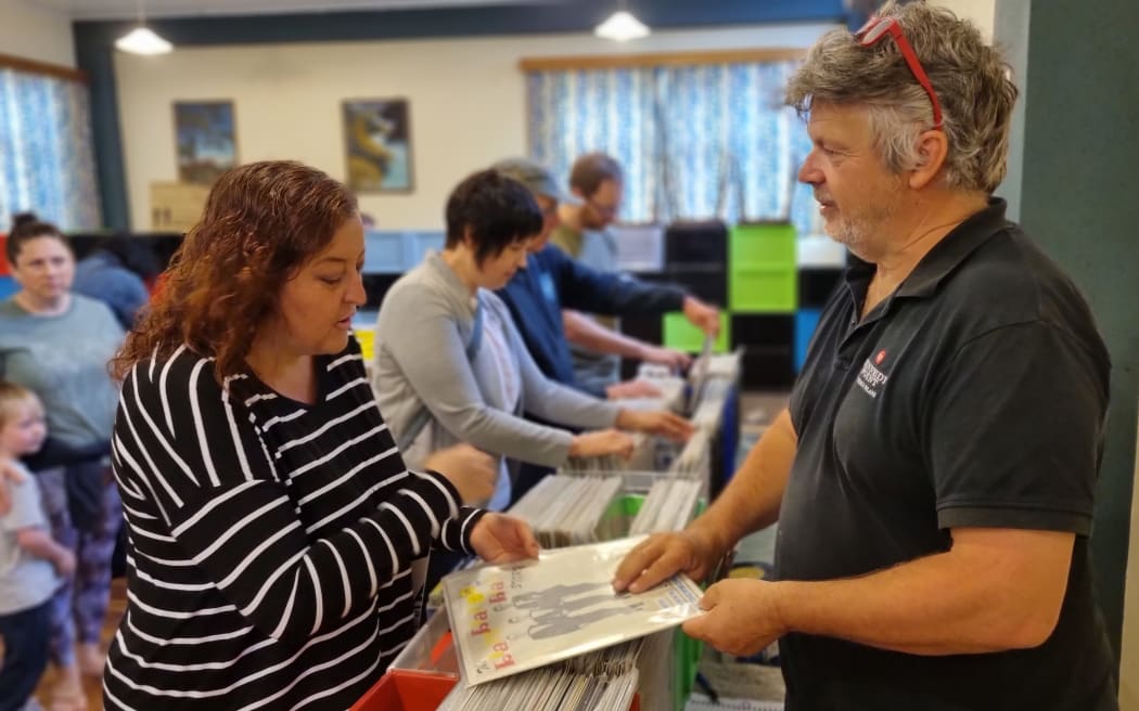Peter White helps Sarah Sampson choose a record at the New Plymouth Record Fair.