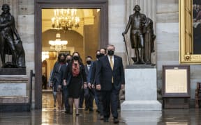 House impeachment managers proceed through the Capitol Rotunda from the House side of the US Capitol to the US Senate chamber.