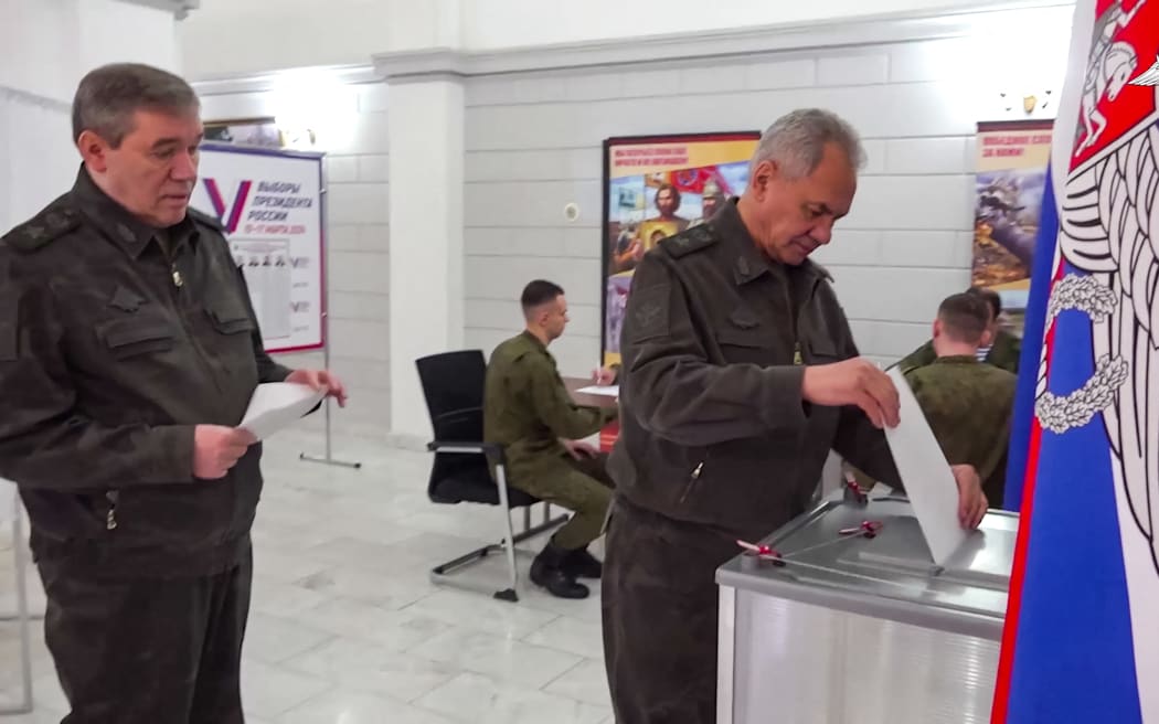 In this grab from a handout footage released by the Russian Defence Ministry on March 15, 2024, Russia's Defence Minister Sergei Shoigu (R) and Army chief of staff Valery Gerasimov vote in Russia's presidential election.
