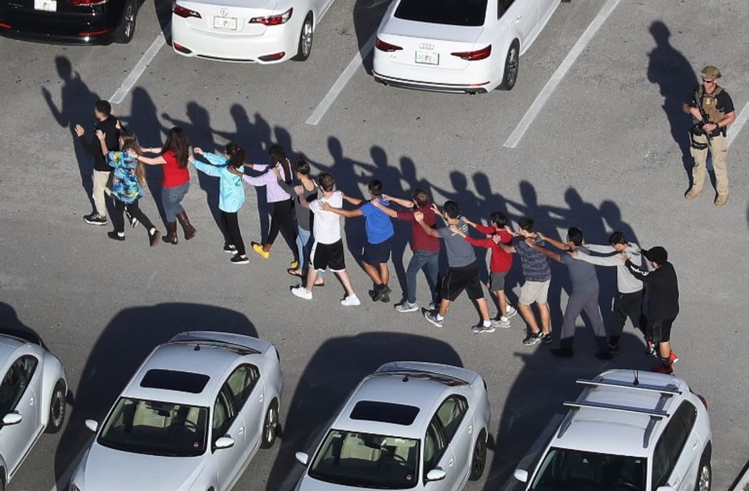 People are brought out of the Marjory Stoneman Douglas High School after a shooting at the school.