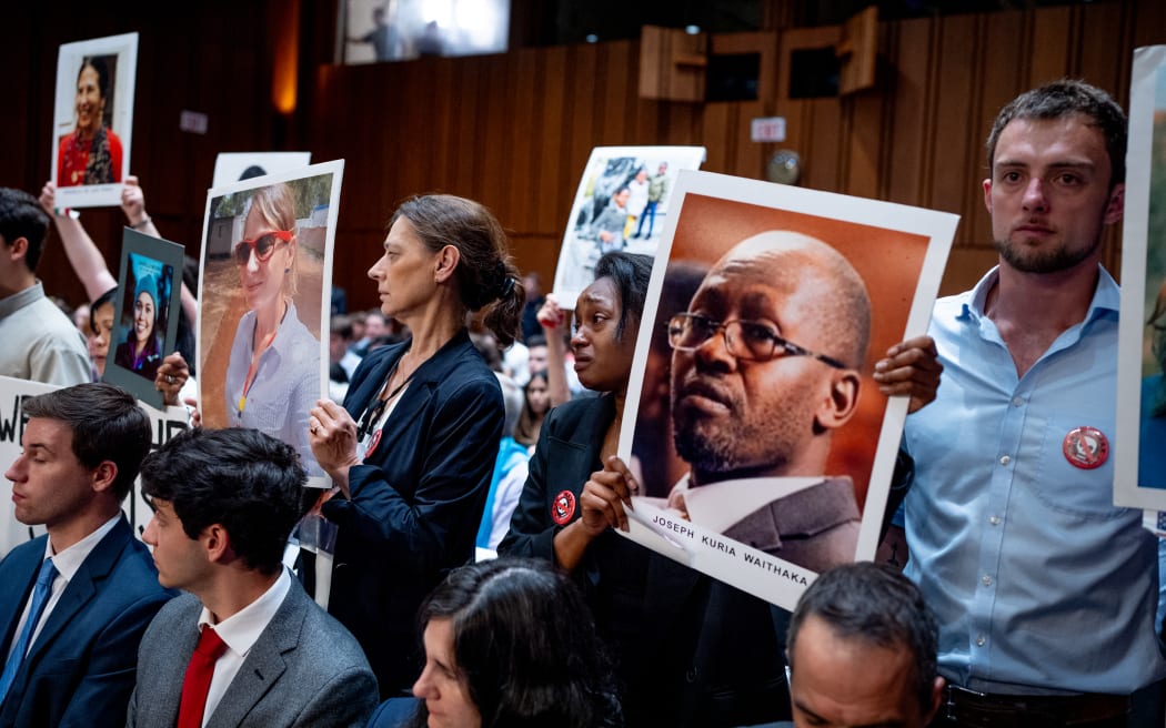 WASHINGTON, DC - JUNE 18: Zipporah Kuria (C) becomes emotional as she holds a photograph of her father Joseph Kuria Waithaka and stands with other family members of those killed in the Ethiopian Airlines Flight 302 and Lion Air Flight 610 as Boeing CEO Dave Calhoun appears before a Senate Homeland Security and Governmental Affairs Investigations Subcommittee hearing on Boeing's broken safety culture on Capitol Hill on June 18, 2024 in Washington, DC. Calhoun says he is "here to take responsibility" as he testifies before the Senate to discuss ongoing quality and safety issues after a new 737 Max 9 airplane's door panel blew out mid-flight during an Alaska Airlines flight in January.   Andrew Harnik/Getty Images/AFP (Photo by Andrew Harnik / GETTY IMAGES NORTH AMERICA / Getty Images via AFP)