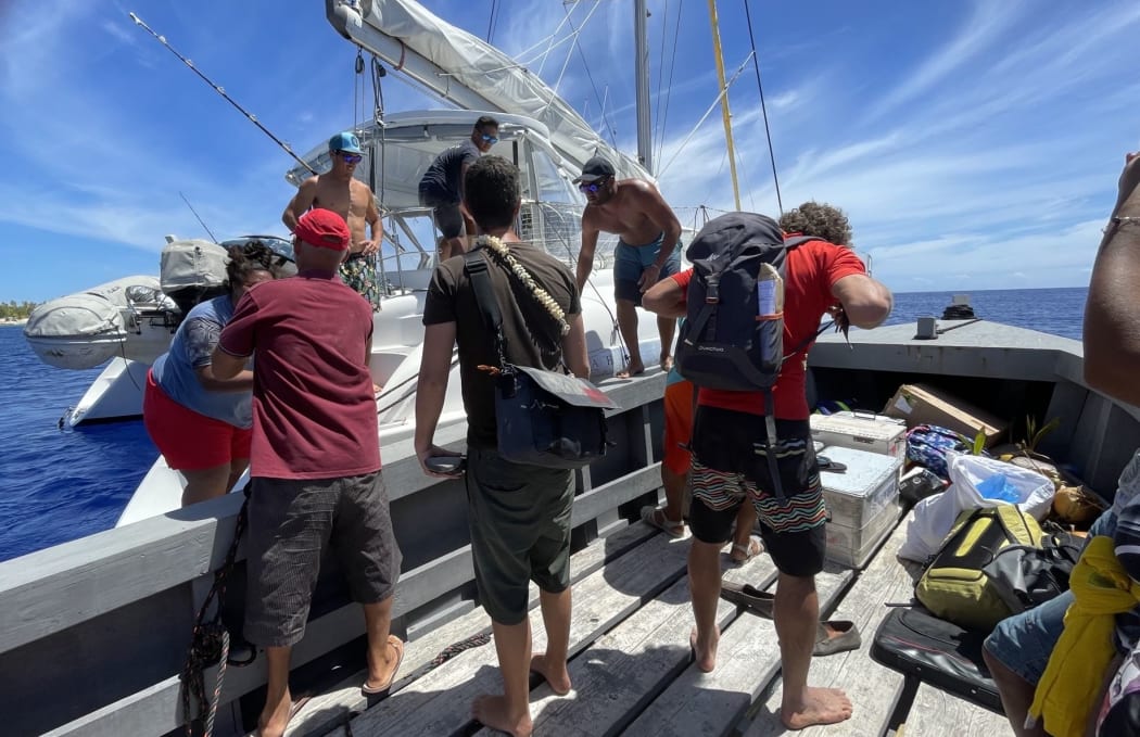 Medical mission transferring gear onto a barge before heading to Hereheretue atoll