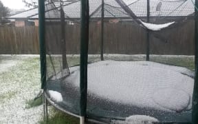 Hail fills a trampoline in a west Auckland backyard.