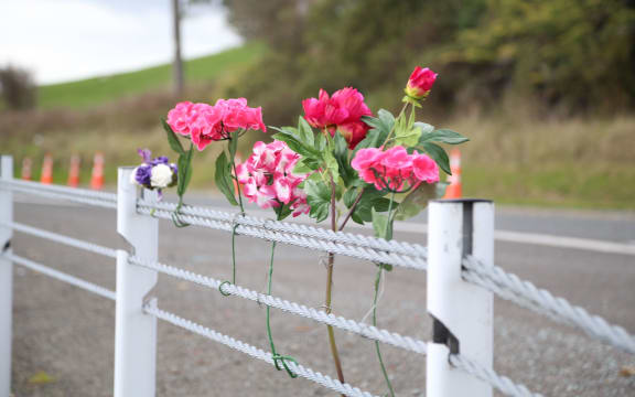 Flower were left at the roadside where an unladen logging truck hit the car the men were travelling in.