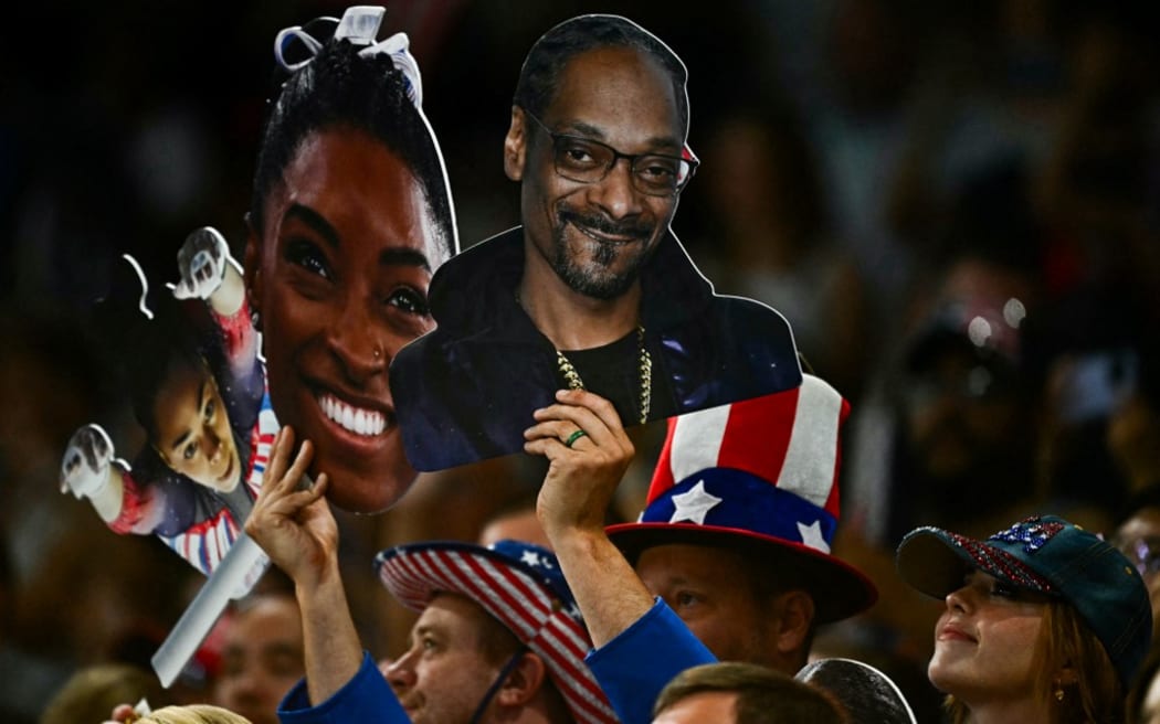 Supporters hold pictures of US' Simone Biles and Us rapper Snoop Dogg during the artistic gymnastics women's team final during the Paris 2024 Olympic Games at the Bercy Arena in Paris, on July 30, 2024. (Photo by Gabriel BOUYS / AFP)