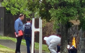 Police officers, some in white forensic suits, collecting samples from the area.