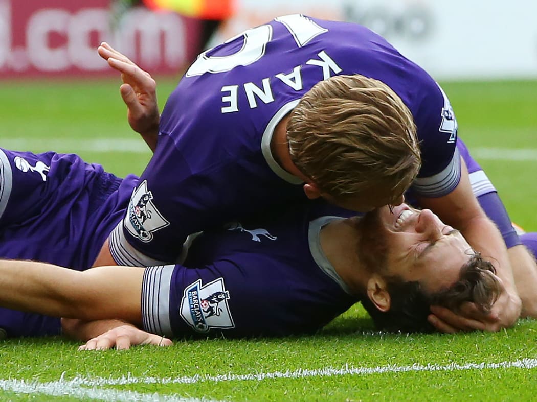 Tottenham Hotspur striker Harry Kane (up) attends to midfielder Ryan Mason, as he lies injured after scoring AFP PHOTO / IAN MACNICOL