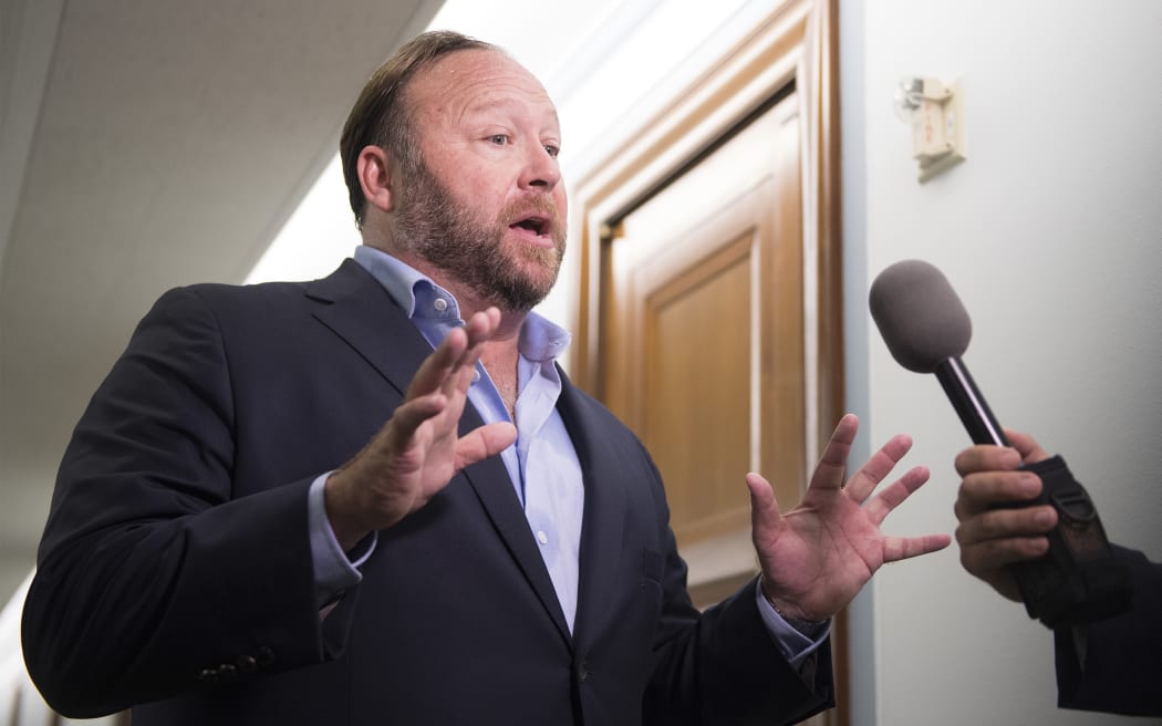 Alex Jones speaks with reporters outside as Twitter CEO Jack Dorsey and Facebook COO Sheryl Sandberg testify before the Senate Intelligence Committee on Capitol Hill in Washington, DC on 5 September 2018.
