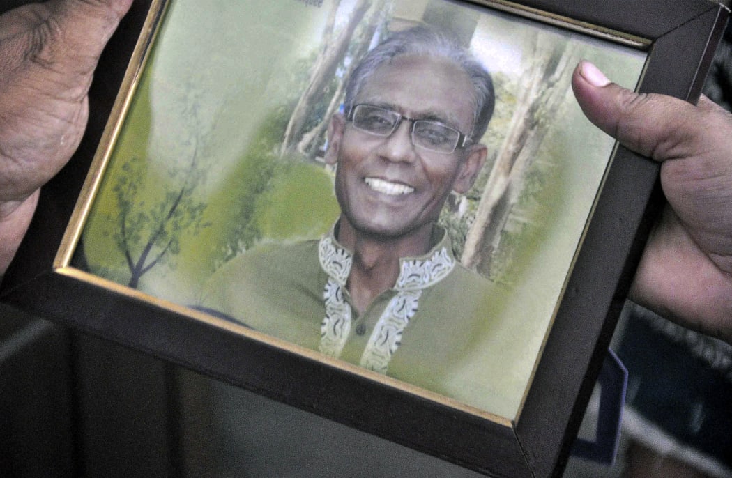 A man holds a portrait of Bangladeshi professor Rezaul Karim Siddique, who was hacked to death by unidentified attackers last week.