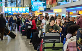 People standing in a queue at Schiphol airport in Netherland as holiday season puts a strain on airlines.