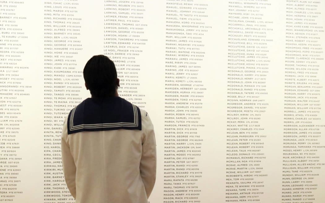 A navy sailor reads the names adorning the walls of the memorial gallery at Te Rau Aroha, the Museum of the Price of Citizenship.