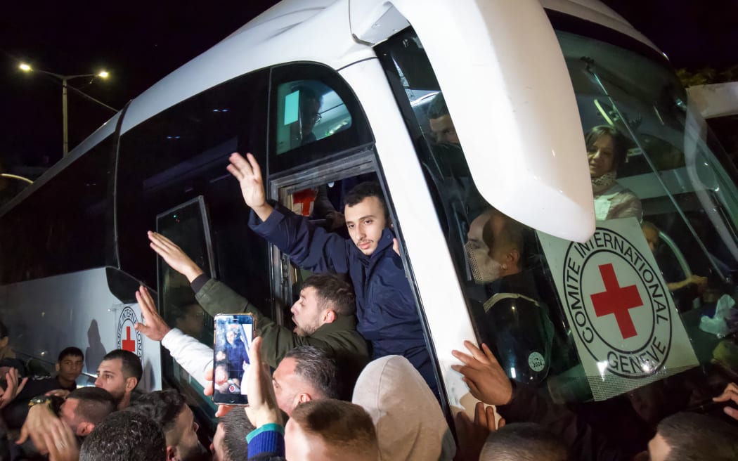 Newly released prisoners disembark a bus during a welcome ceremony following the release of Palestinian prisoners from Israeli jails in exchange for Israeli hostages held in Gaza by Hamas since the October 7 attacks, in Ramallah in the occupied West Bank early on November 30, 2023.