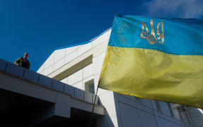 A serviceman of the pro-Ukrainian Aydar battalion stands near the Ukrainian flag at the Lugansk thermoelectric power station.