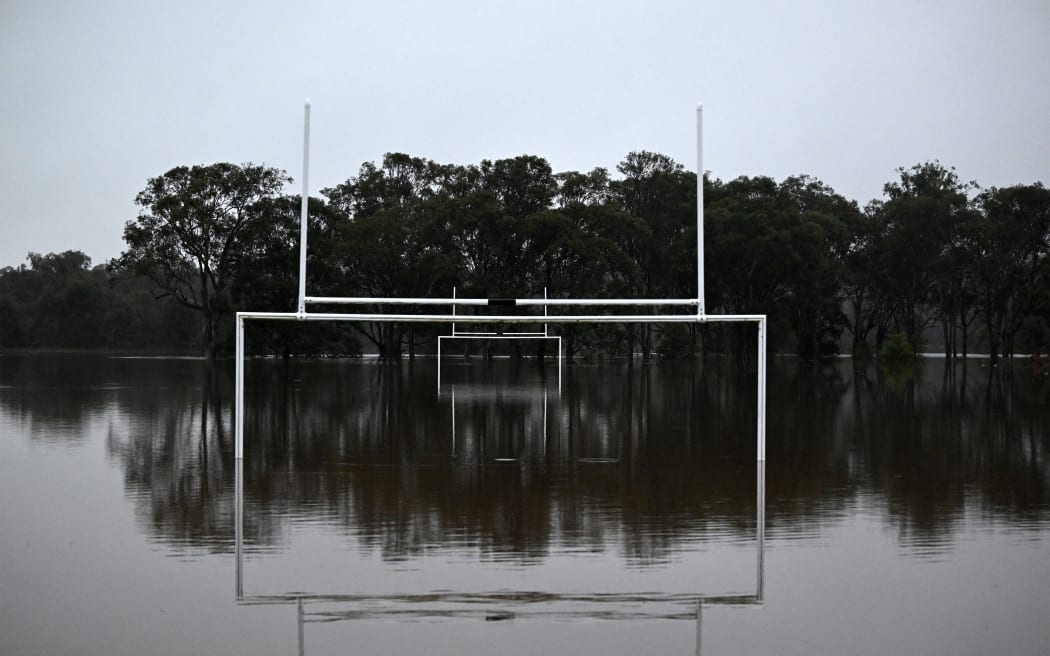 Water level rises inside Cliftleigh Meadows Park from the over flowing Wallis Creek in Gillieston Heights near New South Wales town of Maitland on May 23, 2025. Record floods cut a destructive path through eastern Australia on May 23, caking houses in silt, washing out roads and separating 50,000 people from help. (Photo by Saeed KHAN / AFP)